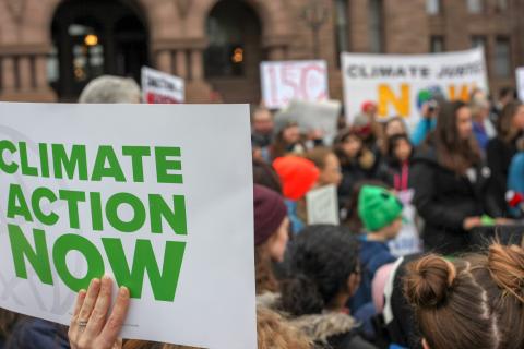 Climate Action Now sign at a street demonstration. Photo via Pixabay
