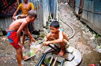 Children gather water in Dhaka, Bangladesh