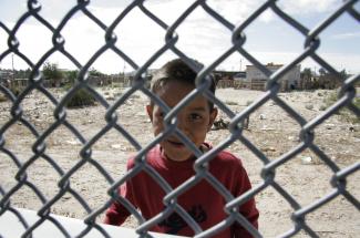 Boy on Mexican side of the border fence in El Paso
