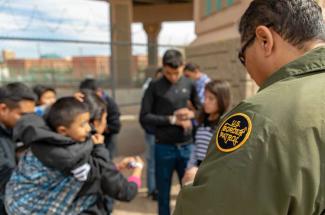 U.S. Border Patrol agent apprehends migrants who surrendered to him after crossing the Rio Grand River in El Paso Texas on March 18, 2019. Credit: U.S. Customs and Border Protection by Mani Albrecht