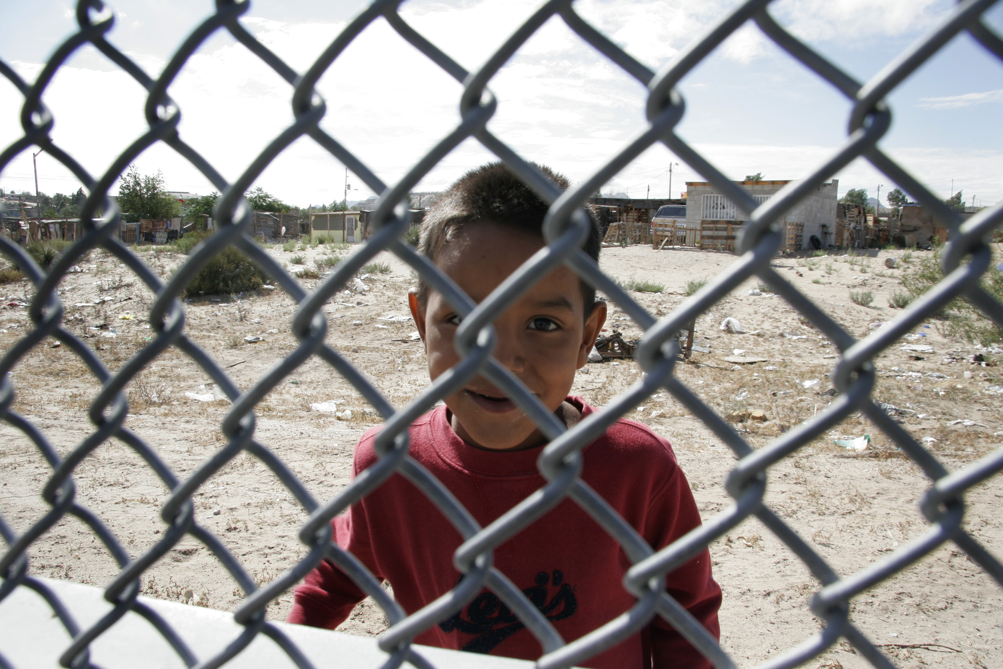 Boy on Mexican side of the border fence in El Paso